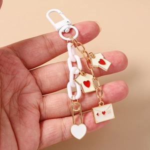 Detail of chunky chain keychain featuring heart t-shirt charms and envelope pendant