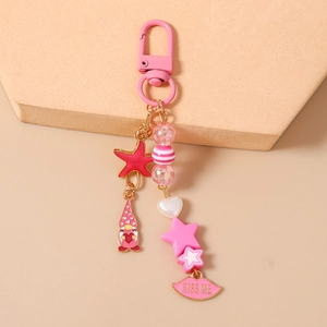 Detail of pink keychain with star, starfish and kiss me lip pendants on a display stand