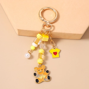 Détail du porte-clés ours jaune avec perles et pendentif d'ours orné de strass