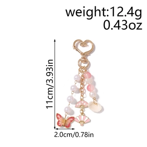 Detailed view of pink starfish shell keychain with gold heart clasp and enamel butterfly