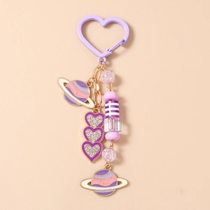 Détail de porte-clés coeur violet avec breloques planète et perles en cristal brillantes
