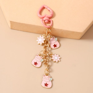 Detailed view of lucky cat keychain with pink heart clasp and floral pendants