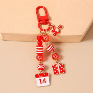 Detail of red beaded keychain featuring Love charm and February 14 calendar pendant