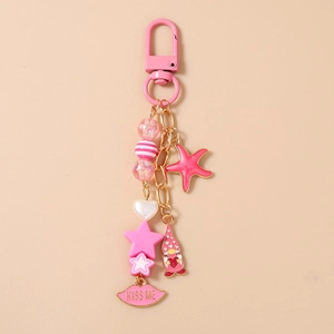 Detail of pink starfish keychain with golden metal chain and Kiss Me lip charm