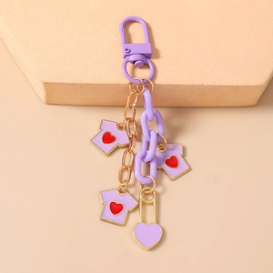 Detail view of purple heart keychain with gold link chain and T-shirt enamel pendants