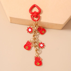 Detailed close-up of lucky cat keychain with red heart clasp and enamel charms