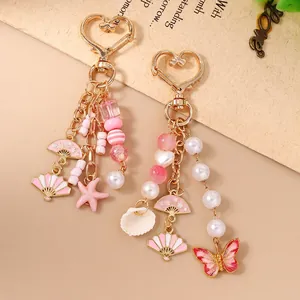 Fashionable keychain with starfish, shell charms, and pink beaded butterfly and fan pendants