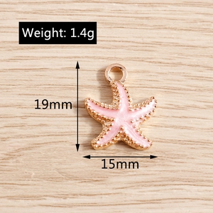 Pink enamel starfish charm detail showing 19x15mm dimensions and 1.4g weight on wood