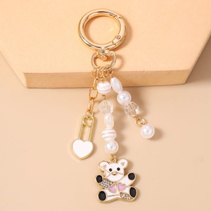 Détail d'un porte-clés ours doré avec perles, pendentif cœur et accents de cristaux brillants