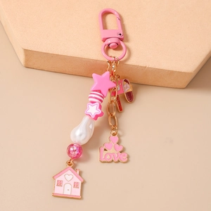 Detailansicht vom rosa Schlüsselanhänger mit Hausmotiv, Sternen und Karabinerverschluss