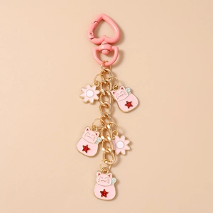 Detailed view of pink lucky cat pendants and flowers on a gold-tone metal keychain