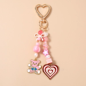 Detailed view of pink beaded keychain with cute bear pendant and golden heart clasp