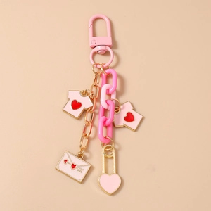 Detail of pink heart keychain with mini T-shirts, envelope charms and gold chain
