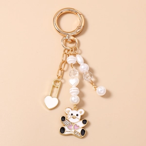 Détail du porte-clés perlé avec pendentif ours en émail blanc et breloques en perles