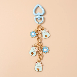 Detail of blue heart clasp and light green lucky cat pendants on a gold chain