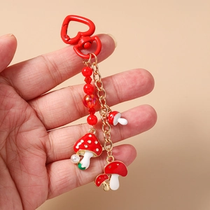 Détail du porte-clés champignon perlé avec fermoir cœur rouge et perles blanches