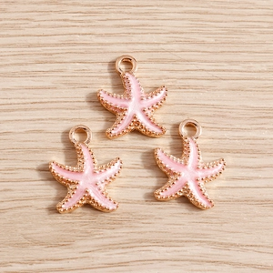 Close-up of pink enamel starfish alloy pendants with gold plating for DIY jewelry making