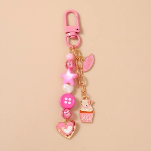 Detailaufnahme eines rosa Harz-Schlüsselanhängers mit Herz- und Cupcake-Anhängern