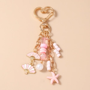 Detail of pink starfish keychain with heart-shaped clasp and floral fan charms