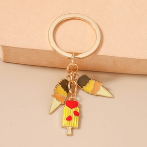 Détail d'un porte-clés doré avec trois pendentifs crème glacée colorés et un cœur