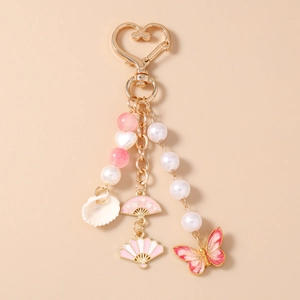 Detail of heart clasp keychain with starfish shell and pink butterfly charm