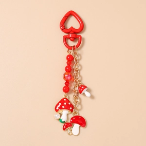 Détail du porte-clés champignon avec fermoir cœur rouge et perles élégantes