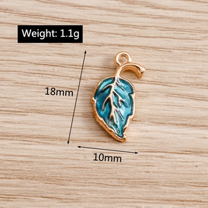 Detail view of blue enamel maple leaf pendant with 18mm height measurement on wood
