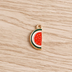 Macro shot of watermelon enamel charm showing detailed red pulp and golden alloy base