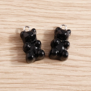 Close-up of black resin gummy bear charms with silver loops for jewelry making