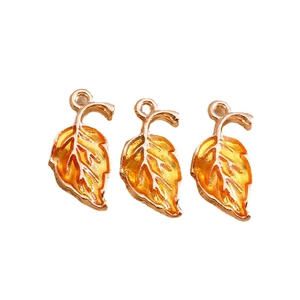 Three orange enamel maple leaf charms with golden metal veins for DIY jewelry making