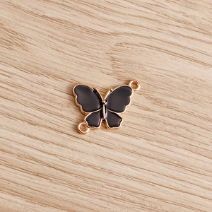 Macro detail of black enamel butterfly pendant with double gold loops for DIY jewelry
