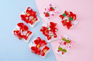 Detailed view of Christmas bow hair clips with reindeer and snowman resin charms on cards