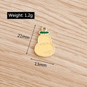 Detail view of pear-shaped alloy pendant with yellow enamel and green leaf design