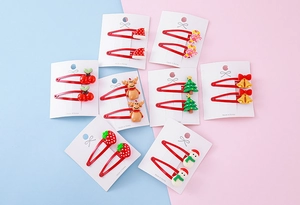 Close-up of Christmas resin bow hair clips featuring Santa hats and reindeer on display cards