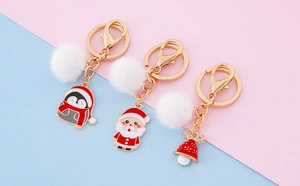 Détail des porte-clés de Noël avec breloques en métal et boules de poils en peluche blanche