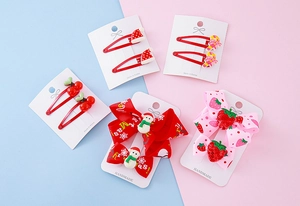 Detail of Christmas kids hair clip set with resin bow, snowman, and strawberry charms