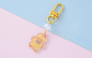 Λήψη macro του μπρελόκ αρκουδάκι gingerbread με χρυσό κούμπωμα και ιριδίζουσα χάντρα
