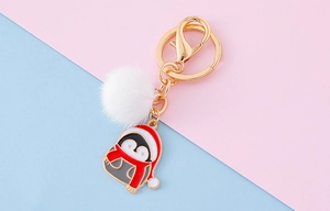 Détail de porte-clés pingouin avec pompon blanc doux et pendentif de Noël festif