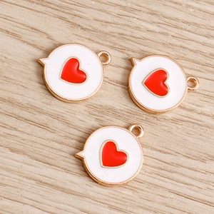 Detailed macro of three white enamel alloy heart pendants on a wooden background