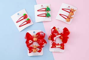 Detailed view of kids Christmas hair clip set with resin strawberry and reindeer bows