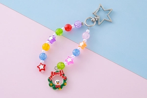 Close-up of a Christmas snowman wreath keychain with colorful acrylic beads and silver star clip