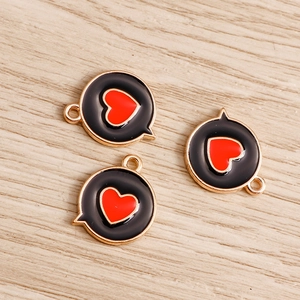 Macro shot of three black enamel heart bubble pendants on a light wood background