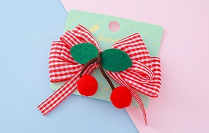 Détail de la barrette à nœud vichy rouge avec pompons cerises et feuilles en feutre