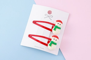 Detail of two red snowman BB hair clips with 3D resin design on display card