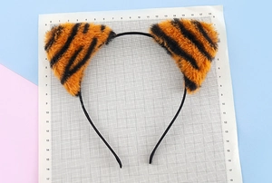 Close-up of leopard print cat ear headband with soft plush fabric and measurement scale