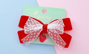 Vue détaillée du nœud en velours rouge avec dentelle et pendentif fraise sur porte-bijoux