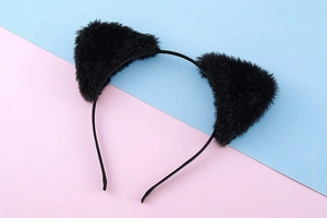 Detail of plush black cat ear headband featuring soft faux fur on a colorful background