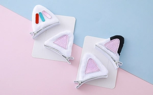 Détail de barrettes oreilles de chat en peluche avec paillettes roses et pinces argent
