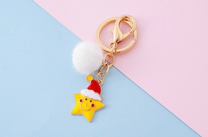 Détail d'un porte-clés étoile de Noël avec pompon blanc en fausse fourrure et fermoir doré