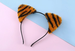 Detail of plush cat ears headband featuring orange and black tiger print stripes